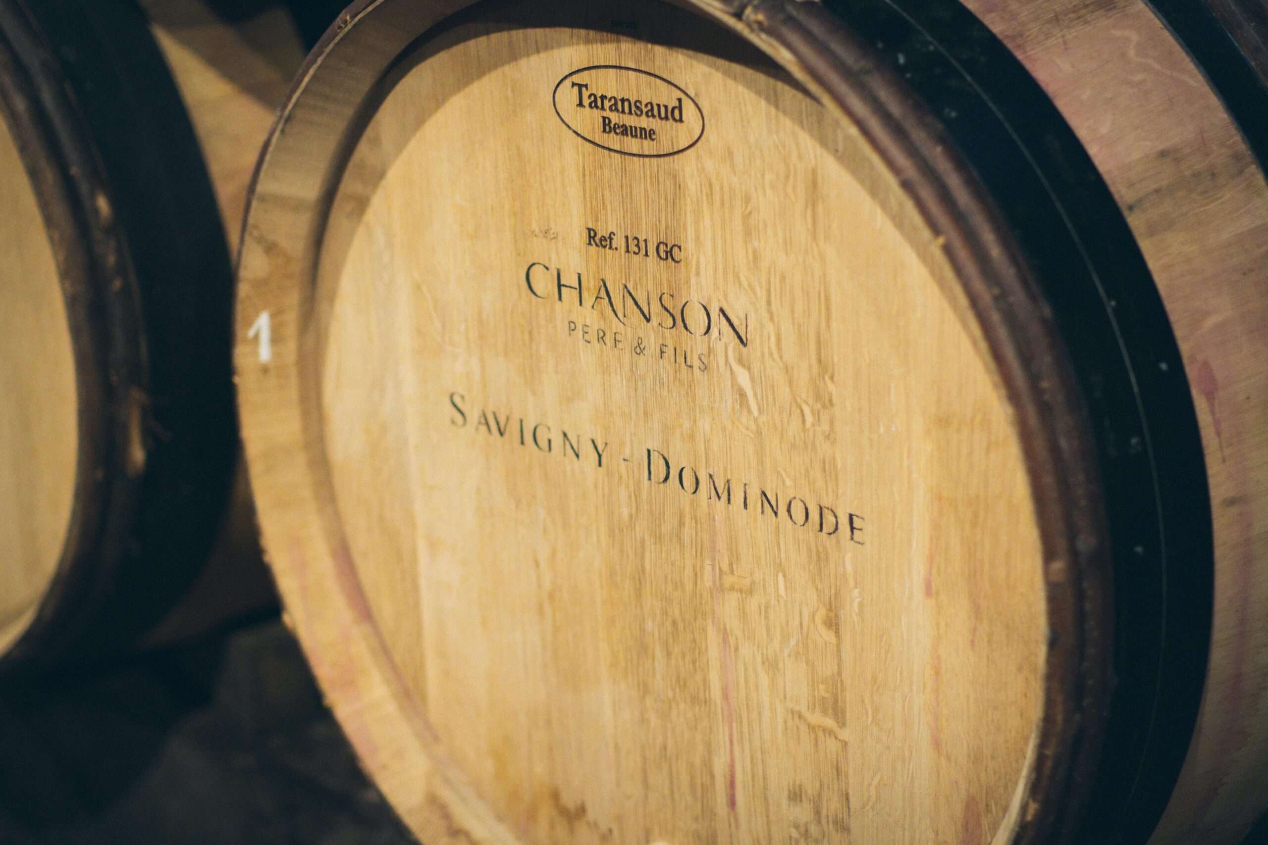 Close-up of wooden wine barrels in a cellar at a winery, showcasing detailed engravings.